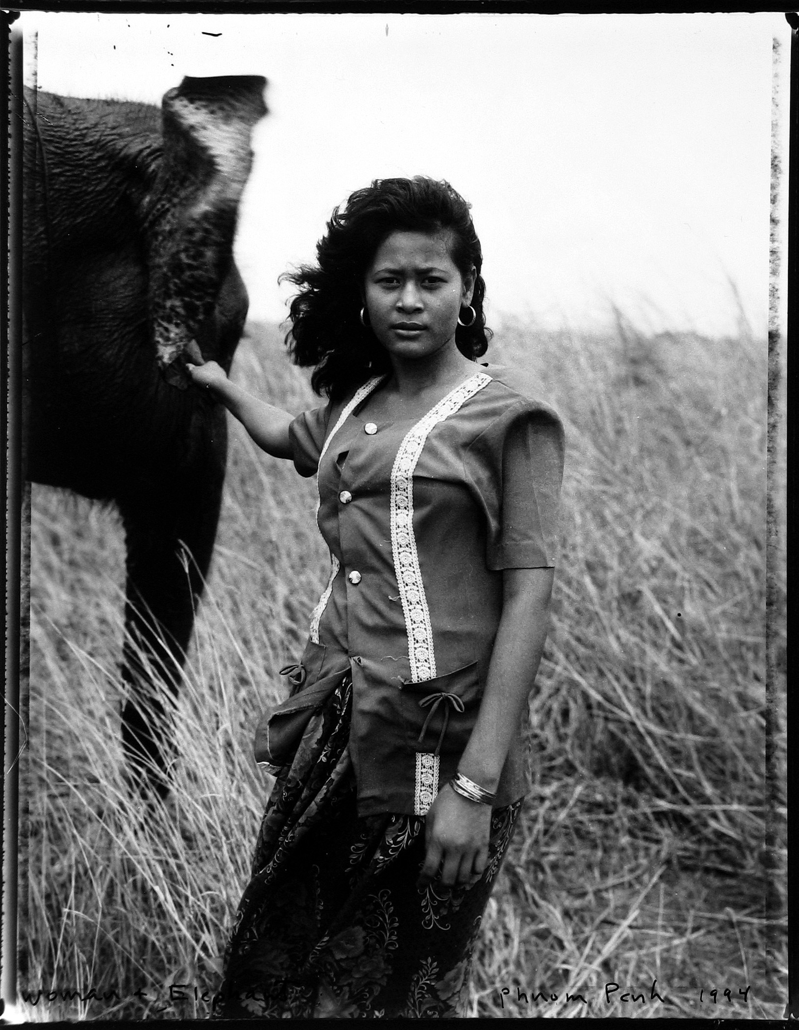 Bill Burke - Woman and elephant, Phnom Penh, 1994 - Howard Greenberg Gallery