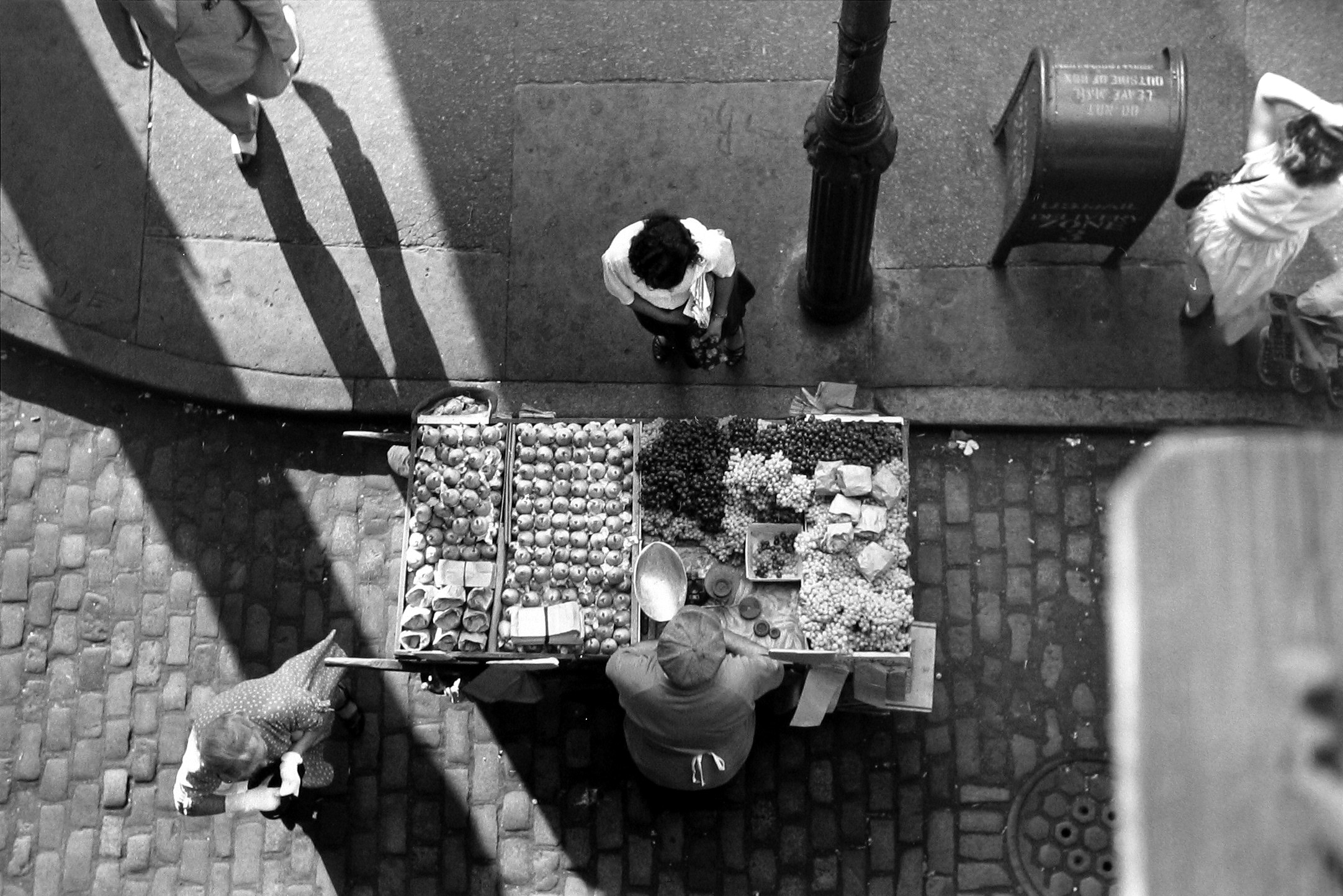 Ruth Orkin - Fruit Stand under Third Avenue El, c.1949 - Howard Greenberg Gallery