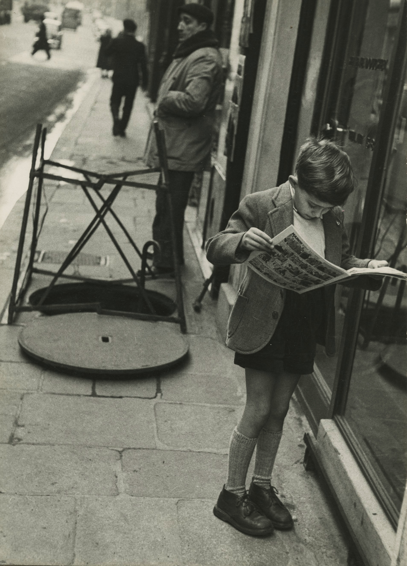 Louis Stettner - Boy Reading Comics, Paris, 1952 - Howard Greenberg Gallery
