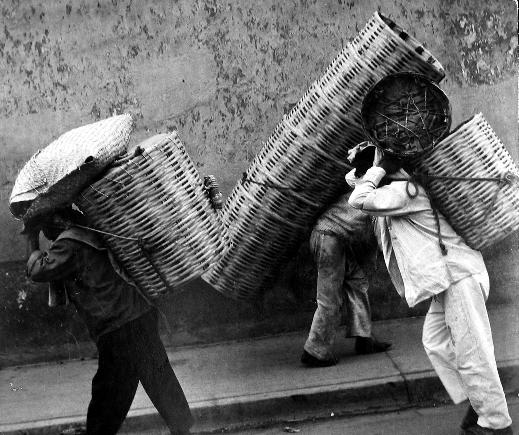 Leon Levinstein, Untitled (men hauling carrying baskets on heads on backs), n.d., Howard Greenberg Gallery, 2019