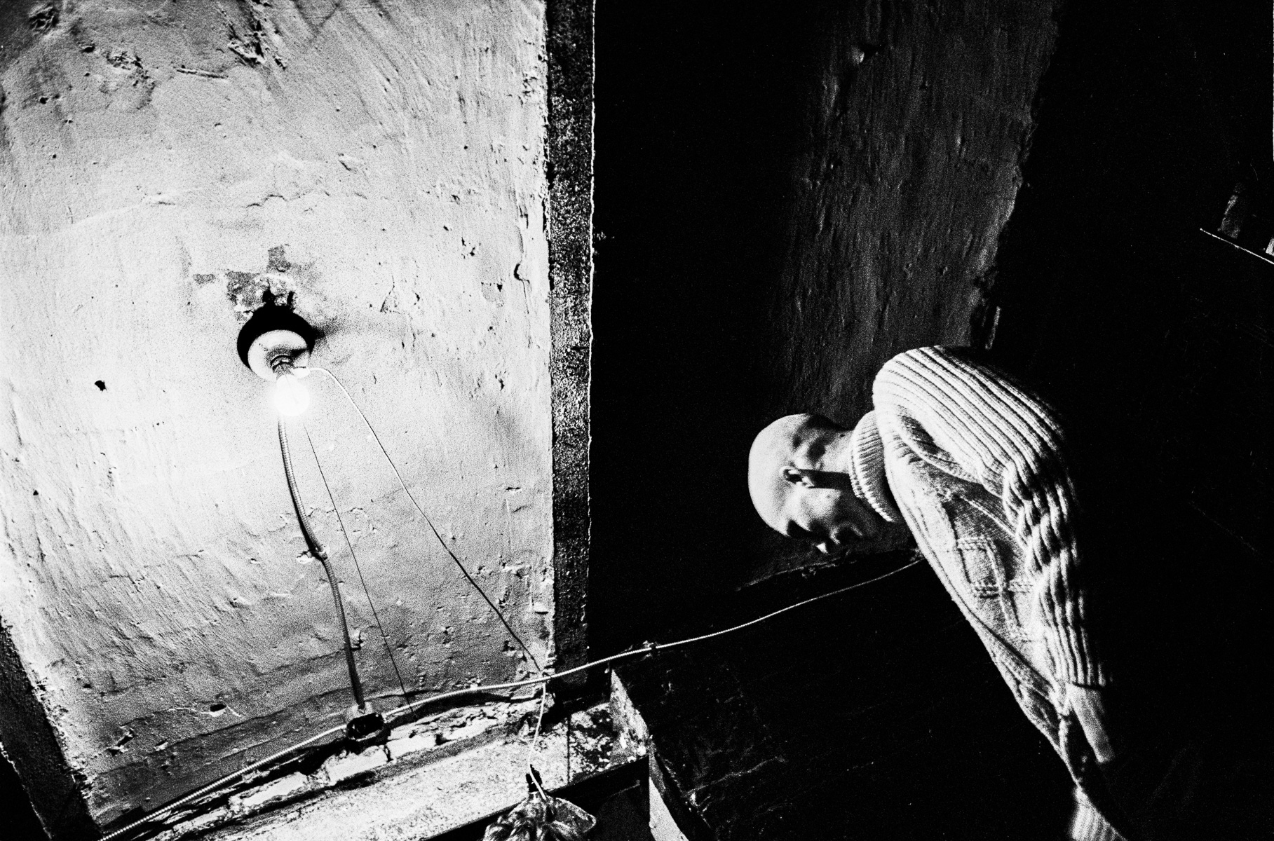 Ken Schles - Craig In Basement With Bare Lightbulb, 1984 - Howard Greenberg Gallery