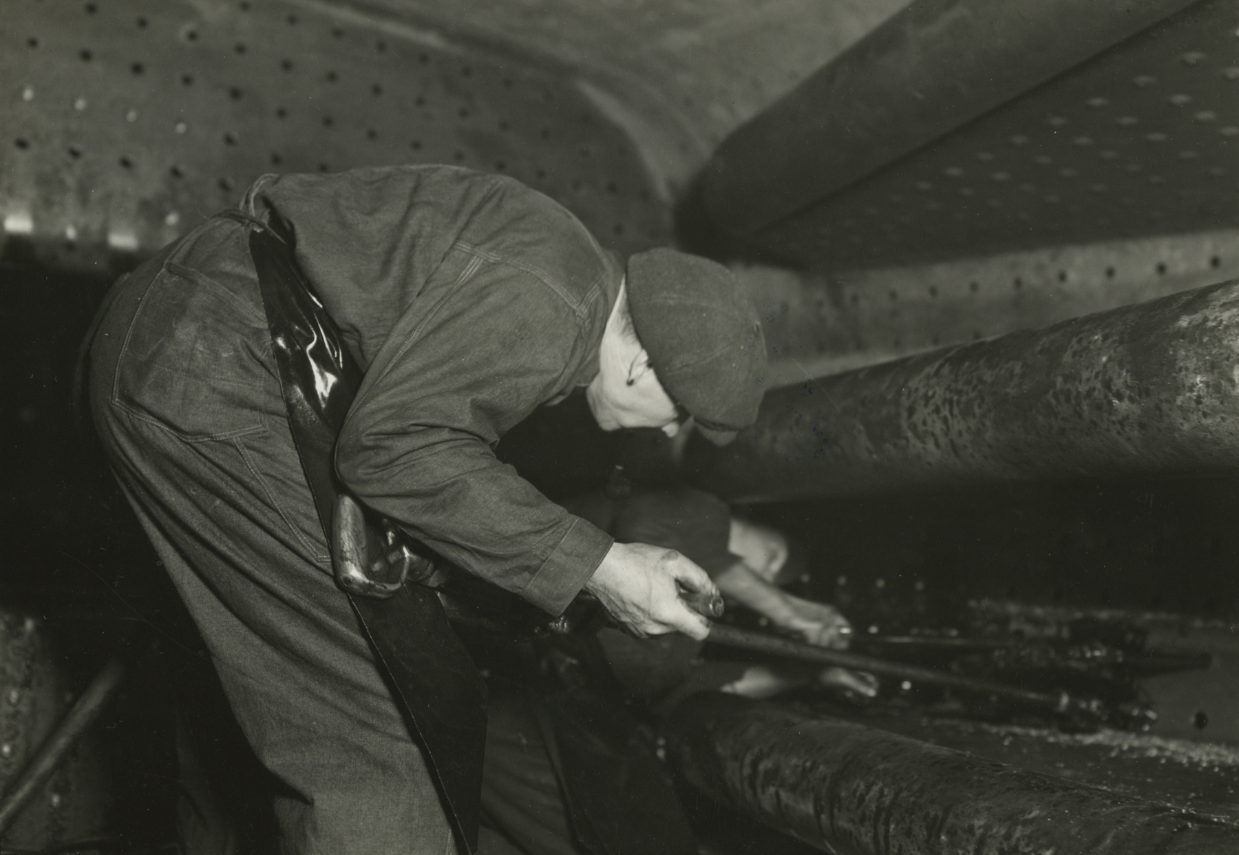 Lewis hine, Boilermaker tapping for stay-bolts in boiler of a modern locomotive, Eddystone, Pennsylvania, March 1937   Gelatin silver print; printed c.1937   4 5/8 x 6 5/8 inches
