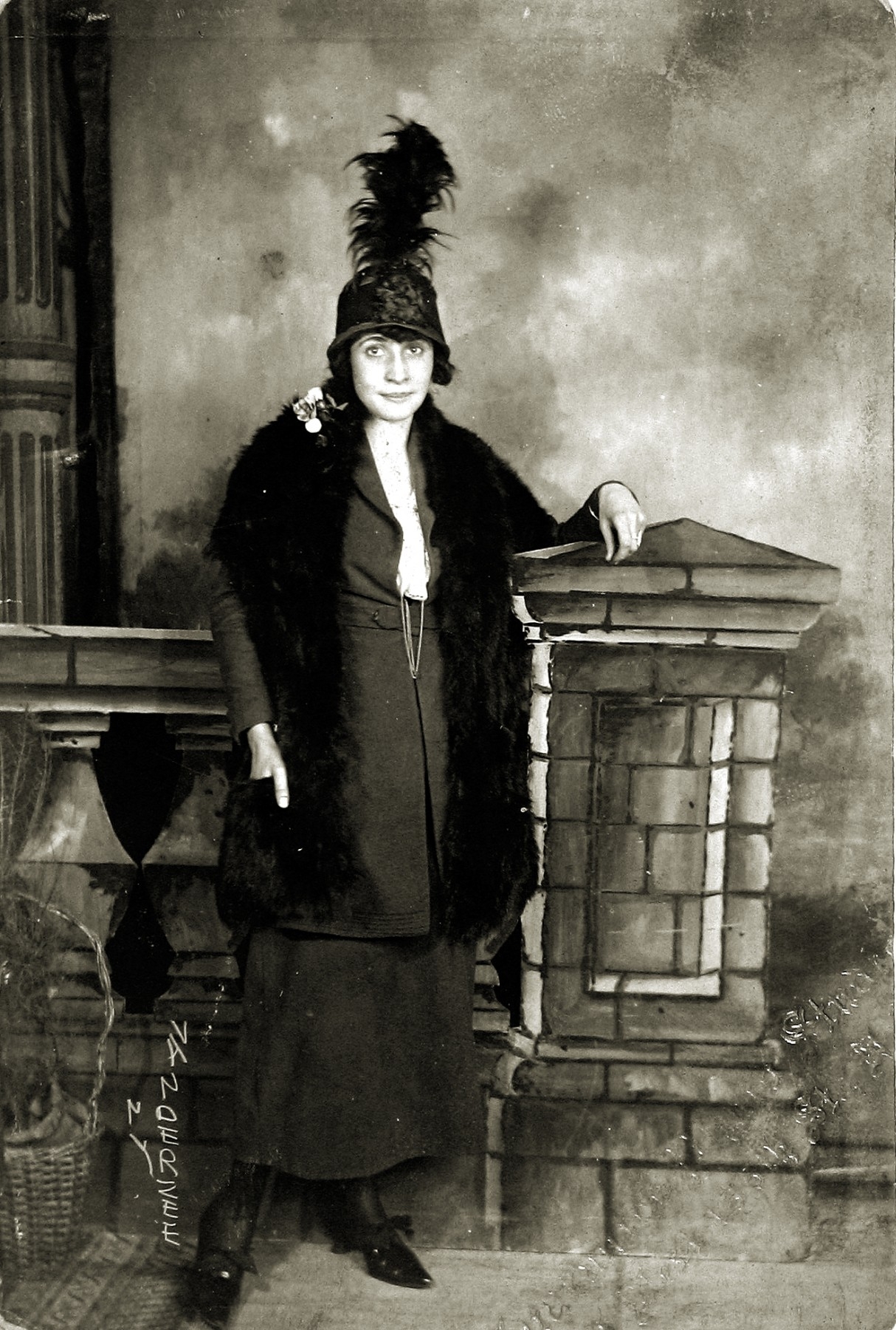 James Van Der Zee - Untitled (Woman with feathered hat in front of painted studio backdrop), c.1925 - Howard Greenberg Gallery - 2019