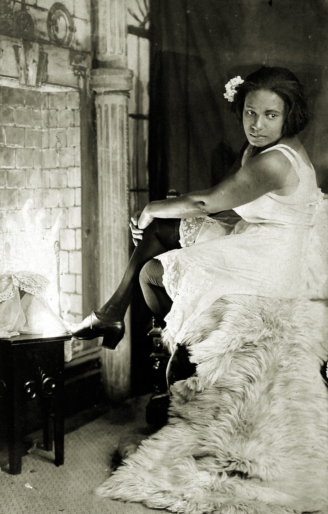 James Van Der Zee - Untitled (young woman in front of painted backdrop of fireplace), c.1925 - Howard Greenberg Gallery - 2019